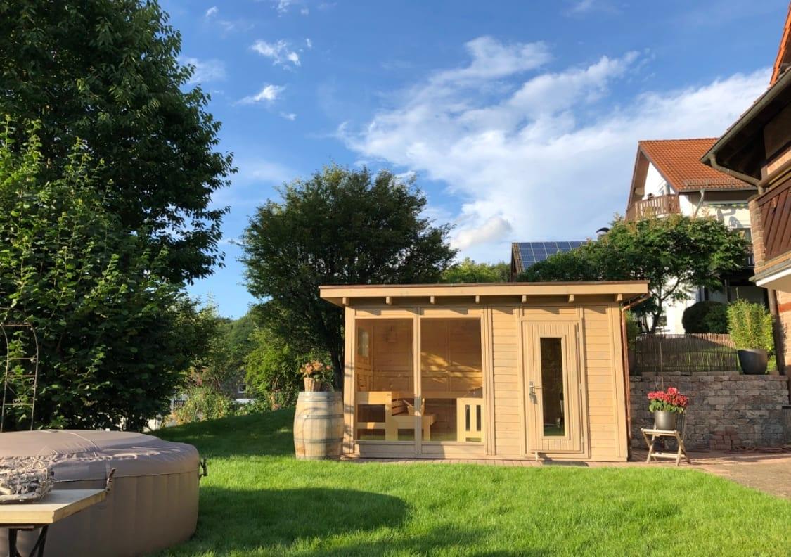 Tirano Gartensauna mit Glasfront im sommerlichen Garten