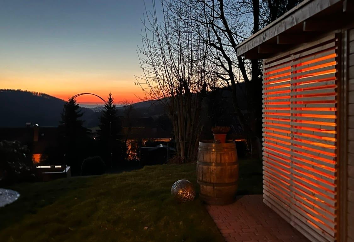 Tirano Gartensauna geschützt in den Garten integriert